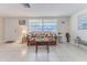 Bright living room featuring tile flooring, a cozy wicker sofa, and ample natural light at 13705 Allyn Dr, Hudson, FL 34667