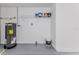 Utility room with water heater, painted concrete floor, and wire shelving at 13705 Allyn Dr, Hudson, FL 34667