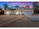 Single-story home with an attached garage showcasing warm exterior lighting and a modern design at 16434 Medley Rd, Weeki Wachee, FL 34614