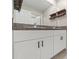 Bathroom featuring double sinks, granite countertops, and rustic floating shelves at 194 Argyll Dr, Spring Hill, FL 34609