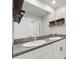 Bathroom featuring double sinks, granite countertops, and rustic floating shelves at 194 Argyll Dr, Spring Hill, FL 34609