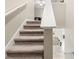 Carpeted stairway leading to a modern kitchen with a granite countertop island at 194 Argyll Dr, Spring Hill, FL 34609
