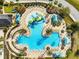 Aerial view of resort-style community pool with zero entry, splash pad, landscaping, and lounge chairs at 20200 Lace Cascade Rd, Land O Lakes, FL 34637