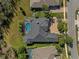 Aerial view of a house with a screened-in pool, lush landscaping, and a brick driveway at 20200 Lace Cascade Rd, Land O Lakes, FL 34637