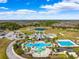 Aerial view of resort-style community pool with splash pad, lap pool, landscaping, and ample parking at 20200 Lace Cascade Rd, Land O Lakes, FL 34637