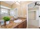 Bathroom with granite counters, wood cabinets, and a decorative mirror. An open doorway leads to the bedroom at 20200 Lace Cascade Rd, Land O Lakes, FL 34637