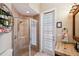 Bathroom with a tiled glass shower, stone sink with dark fixtures, and a decorative glass door at 20200 Lace Cascade Rd, Land O Lakes, FL 34637
