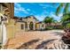 Stunning home exterior featuring a beautifully paved driveway, meticulously kept landscaping, and tropical palm trees at 20200 Lace Cascade Rd, Land O Lakes, FL 34637