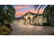 Home at dusk with lush landscaping, brick driveway, and charming architectural details at 20200 Lace Cascade Rd, Land O Lakes, FL 34637