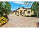 Mediterranean-style home features a spacious driveway and manicured landscaping with mature palm trees at 20200 Lace Cascade Rd, Land O Lakes, FL 34637