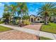 Beautiful luxury home exterior with mature landscaping, brick driveway, and manicured lawn at 20200 Lace Cascade Rd, Land O Lakes, FL 34637