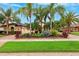 Beautifully landscaped front yard with lush greenery, palm trees, and a well-maintained lawn at 20200 Lace Cascade Rd, Land O Lakes, FL 34637