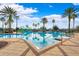 Large community pool and splashpad with palm trees and shaded seating areas at 20200 Lace Cascade Rd, Land O Lakes, FL 34637