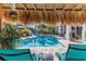 Inviting backyard pool area with tropical landscaping, tiki hut, and relaxing lounge chairs at 3308 Oleander Dr, Hernando Beach, FL 34607