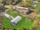 The aerial view shows the green yard of this fenced home in a wooded area at 3323 Parlow Ave, Spring Hill, FL 34606
