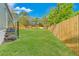 The backyard includes a wooden fence, grassy lawn, and metal stairs for easy access to the home at 3323 Parlow Ave, Spring Hill, FL 34606