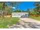 Charming single-story home featuring a well-maintained lawn and a gravel driveway on a sunny day at 3323 Parlow Ave, Spring Hill, FL 34606
