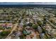 A landscape aerial view showing the home in its neighborhood with mature trees and landscaping at 3540 Linkwood St, New Port Richey, FL 34652