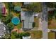 Aerial view of home featuring a round pool, green backyard, and tree-lined property at 3540 Linkwood St, New Port Richey, FL 34652
