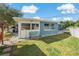 A charming backyard features a blue exterior, patio, lawn, and a comfortable bench at 3540 Linkwood St, New Port Richey, FL 34652