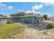 Lovely backyard with brick patio features a blue house and mature landscaping at 3540 Linkwood St, New Port Richey, FL 34652