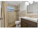 Well-lit bathroom featuring a shower with neutral tile and a dark wood vanity at 3540 Linkwood St, New Port Richey, FL 34652