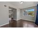 Living room showcasing hardwood floors, a window with a view of the yard, and neutral gray paint at 3540 Linkwood St, New Port Richey, FL 34652