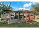 Outdoor bar under a covered patio featuring a built-in grill and swing set at 3540 Linkwood St, New Port Richey, FL 34652