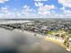 Expansive aerial view showcasing a picturesque coastline, beach, and charming residential area surrounded by tranquil waterways at 3912 Rudder Way, New Port Richey, FL 34652