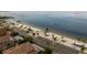 Expansive beach view with parking, cabanas, palm trees, and Gulf waters, perfect for relaxing days at 3912 Rudder Way, New Port Richey, FL 34652