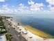 Aerial view of the community beach with a parking lot, beachside palapas, and a boat on the horizon at 3912 Rudder Way, New Port Richey, FL 34652