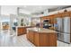 Spacious kitchen featuring granite countertops, a center island, stainless steel appliances, and tile flooring at 3912 Rudder Way, New Port Richey, FL 34652