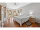 Bright main bedroom boasts hardwood floors, a ceiling fan, and large windows with stylish, neutral curtains at 3912 Rudder Way, New Port Richey, FL 34652