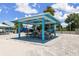 Inviting pavilion with picnic tables on a sandy beach, perfect for outdoor gatherings and relaxation at 3912 Rudder Way, New Port Richey, FL 34652