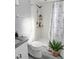 Cozy bathroom features a shower with floral curtain and a wood shelf for toiletries near the toilet at 4218 San Rafael Ave, New Port Richey, FL 34655