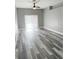 Bright living room with a ceiling fan, sliding glass doors, and modern wood-look floors at 4218 San Rafael Ave, New Port Richey, FL 34655
