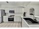 A kitchen features white cabinets, stainless steel appliances, and a black undermounted sink at 7343 Cleopatra Dr, Land O Lakes, FL 34637