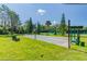 View of the outdoor shuffleboard court with a green lawn and landscaping in a community park at 7343 Cleopatra Dr, Land O Lakes, FL 34637