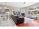 Spacious living room featuring fireplace, large window, and leather sofa, with tiled and hardwood floors at 9033 Callaway Dr, Trinity, FL 34655