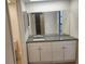 Bathroom vanity with granite countertop and white cabinets beneath a large mirror at 9179 Gillmar St, Spring Hill, FL 34608