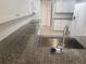Well-lit kitchen with dark granite countertops and stainless steel sink faucet at 9179 Gillmar St, Spring Hill, FL 34608
