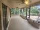 Covered patio with multiple ceiling fans, with access to a screened-in porch and wooded view at 9179 Gillmar St, Spring Hill, FL 34608