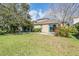 Large grassy backyard with a patio, privacy landscaping, and exterior elevation at 12824 Tikal Way, Trinity, FL 34655