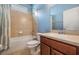 This bathroom offers light tile, a shower/tub combo, and a warm vanity at 12824 Tikal Way, Trinity, FL 34655