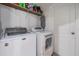 This laundry room features a full-size washer and dryer next to a shelf at 12824 Tikal Way, Trinity, FL 34655