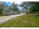 Side view of home showing garage and one of two auxiliary buildings adjacent to a well-kept lawn at 16325 Hibiscus Rd, Brooksville, FL 34601