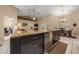 Kitchen island with granite countertop, dark cabinets, and stainless steel appliances perfect for entertaining guests at 16325 Hibiscus Rd, Brooksville, FL 34601