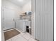 Well-lit laundry room featuring a washer, dryer, utility sink, and tile flooring at 16325 Hibiscus Rd, Brooksville, FL 34601