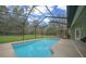 Enjoy a refreshing swim in this screened-in pool overlooking the lush green backyard at 16325 Hibiscus Rd, Brooksville, FL 34601