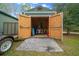 A shed with wide doors and ramp stores a yard tractor and other equipment at 16325 Hibiscus Rd, Brooksville, FL 34601